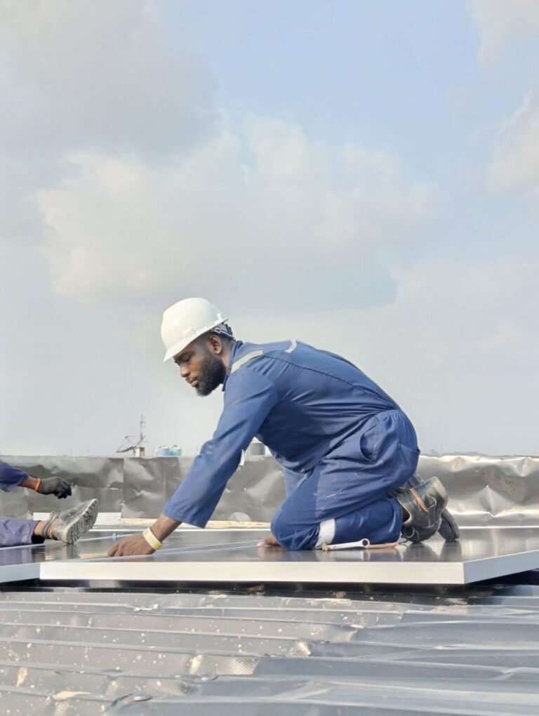 Technician fixing solar panel mounting rails on a metal roof