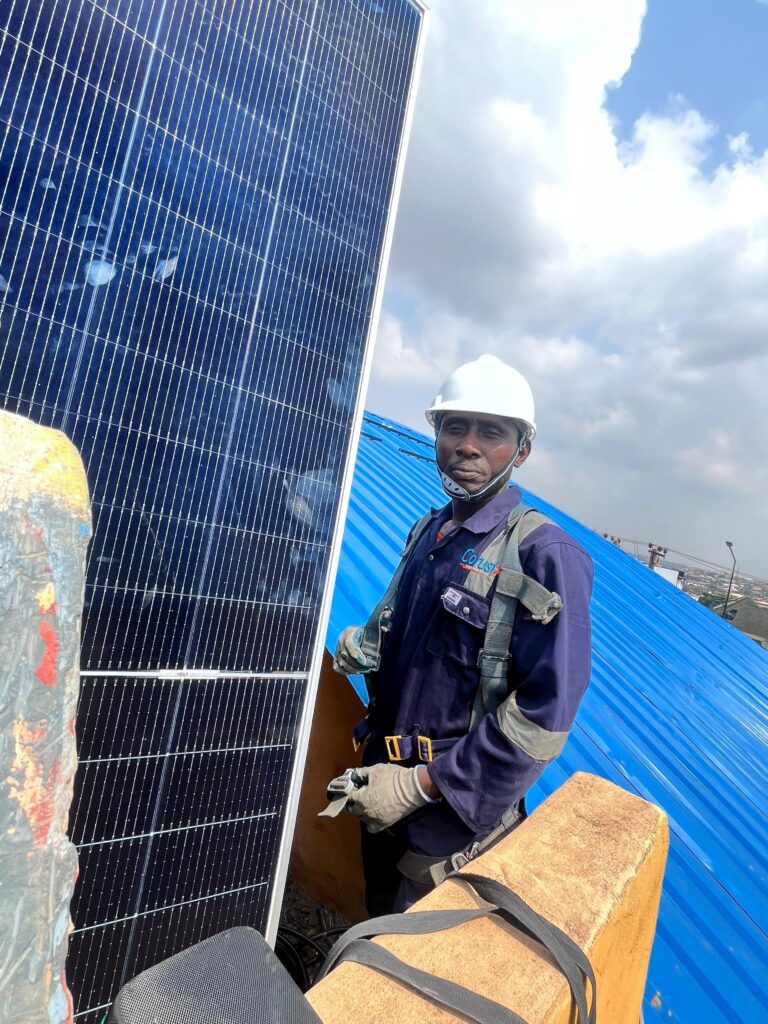 Corustar technician on a roof beside a solar panel