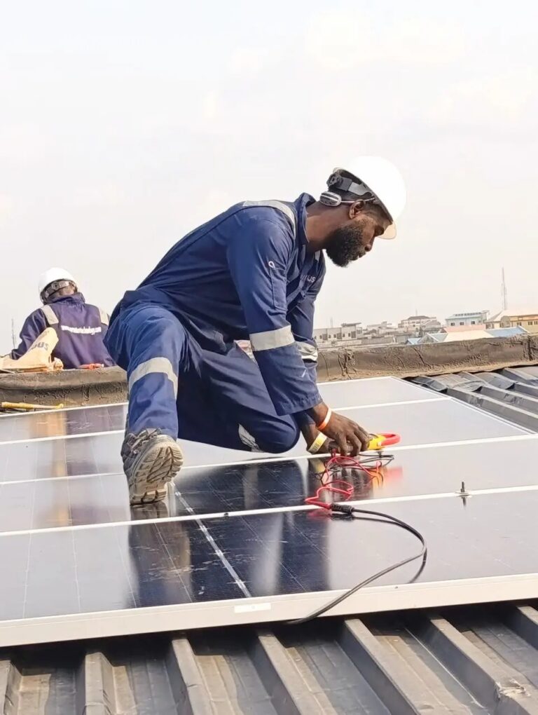 Technician connecting solar panel cables on a rooftop